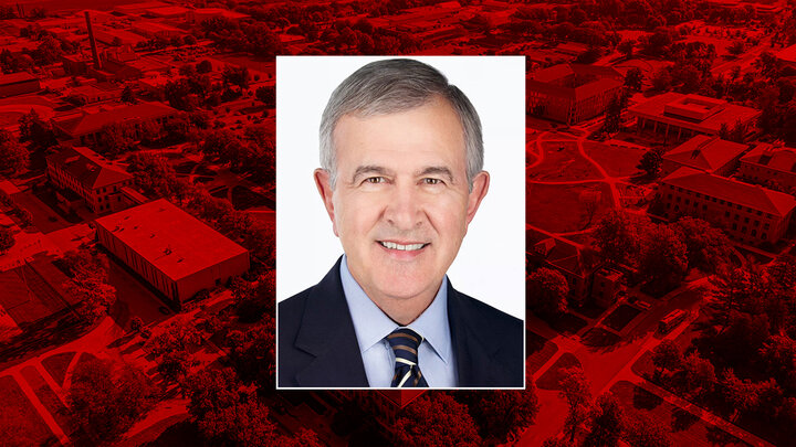 Color portrait of Mike Johanns — former U.S. secretary of agriculture, governor of Nebraska and U.S. senator — on a red East Campus background.