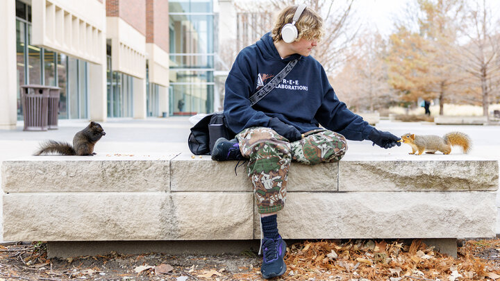 Dalton Dailey, junior, feeds squirrels outside of Love Library. December 17, 2024